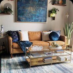 a living room with a couch, coffee table and books on the shelf in front of it