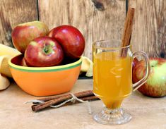 an apple cider with cinnamon and apples in the background