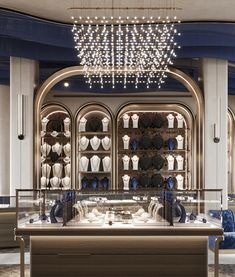 a display case in a store filled with lots of shoes and hats on shelves under a chandelier