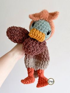 a crocheted stuffed animal is being held up