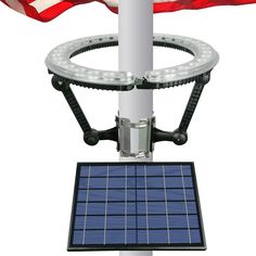 an american flag is in the background with a solar panel attached to a light pole