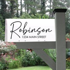 a sign for robinson street in front of some trees and flowers with the name on it