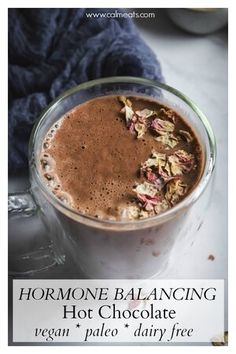 a glass mug filled with hot chocolate and granola florets on the side