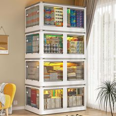 a white shelf filled with lots of books next to a yellow chair