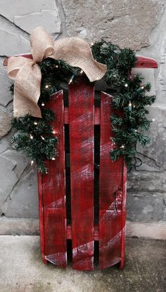 a red sled with wreath and lights on it