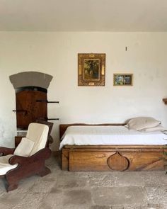 a bedroom with a bed, chair and pictures on the wall