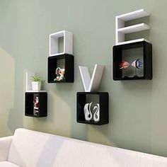 three black and white shelves are on the wall next to a couch with a potted plant