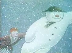 a child standing next to a large snowman