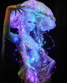 a woman is dressed up as a jellyfish with lights on her head and body