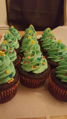 cupcakes decorated with green frosting and sprinkles on a table