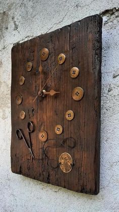 a clock made out of wood with buttons and needles on the side of a building