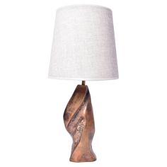 a table lamp with a white shade on it and a gold swirl design in the base