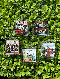 four keychains with pictures of the monkies on them are hanging from a bush