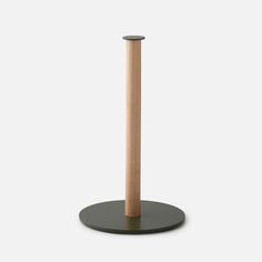 a wooden stick is on top of a black stand with a round base for it