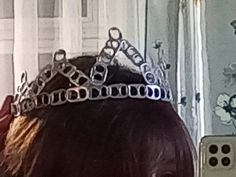 the back of a woman's head with a crown on top of her head