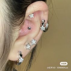 an ear with three stars on it and two piercings attached to the back of the ear