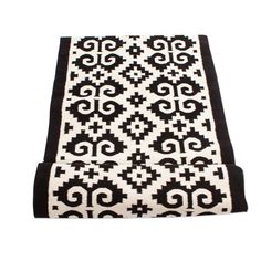 a black and white rug with an intricate design on the bottom, in front of a white background