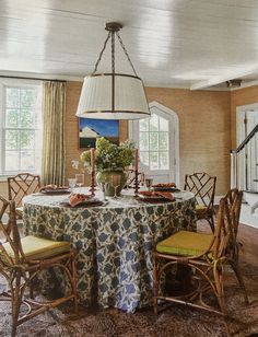 a dining room table with chairs and a chandelier hanging from it's ceiling