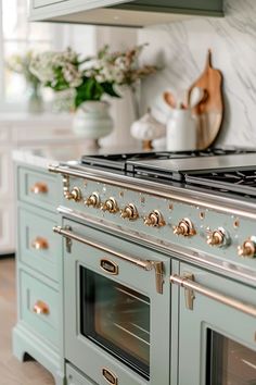 a kitchen with green cabinets and gold knobs