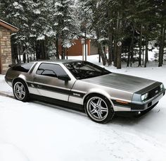 a silver sports car parked in the snow