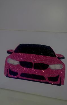 a pink car that is sitting on the wall