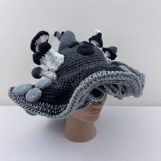 a crocheted hat with black, white and gray animals on the brim