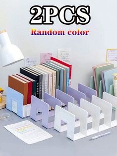 there are many books on the table and one is in front of a lamp that says 2 pcs random color