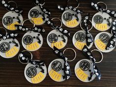 twelve personalized key chains with monogrammed letters and flowers on them, all decorated in black and yellow