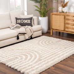 a living room with a white rug and wooden furniture