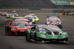 a group of cars driving down a race track