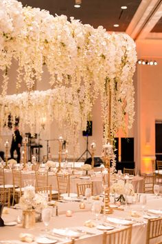 the tables are set with white flowers and place settings