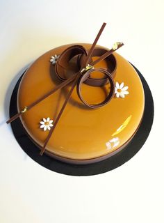 an orange plate with two glasses and sticks in it on a white tableclothed surface