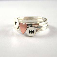 three stack rings with two hearts and the letter n on each one, both in sterling or gold