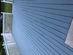 the side of a house with blue siding and white slats on it's sides