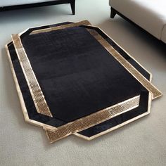 a black and gold rug on the floor next to a couch