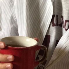 a person holding a red coffee cup in their hands