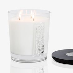 a white candle sitting next to a black coaster