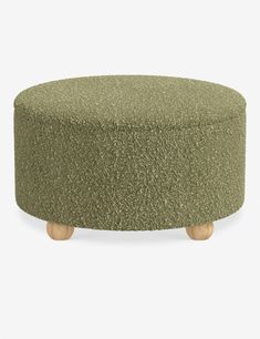 a round ottoman with wooden legs and a green upholstered cover on the top