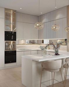 a modern kitchen with white counter tops and stools