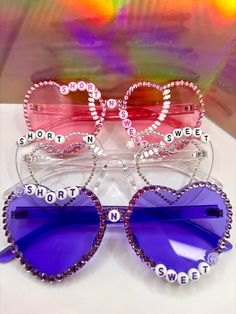 CUSTOM SHORT N SWEET SUNGLASSES COMPLETELY CUSTOMIZABLE: 3 letter layouts available, mix and match colors, option to include city or "tour" (for example: Short N Sweet Tour, Short N Sweet Philly) Rhinestone Bedazzled Sunglasses Available in pink, purple, clear, blue, black, and others by request (please DM) Several design & word options available Concert Sunglasses, Concert Glasses, Bedazzled Sunglasses, Carpenter Outfits, Beaded Sunglasses, Disco Birthday Party, Sabrina Carpenter Outfits, Sunglasses Design, Rave Accessories