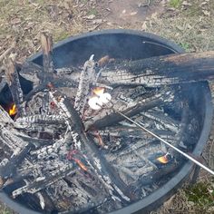 an open fire pit with marshmallows and sticks