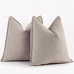 two gray pillows sitting on top of each other