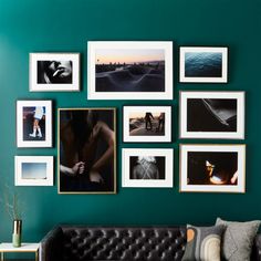 a living room with green walls and pictures hanging on the wall, including a black leather couch