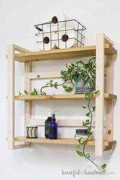 a wooden shelf with plants and toiletries on it