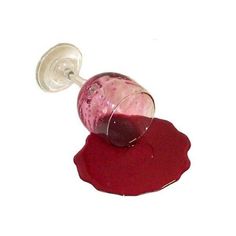 a bottle of liquid sitting on top of a red object with a wine glass sticking out of it