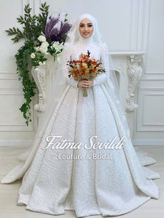 a woman in a white wedding gown holding flowers