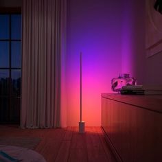 a room with a purple light on the wall and a white lamp next to it