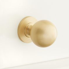 a gold door knob on a white wall