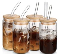 four mason jars filled with iced drinks and straws