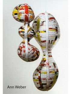 two balls made out of newspaper are hanging from strings